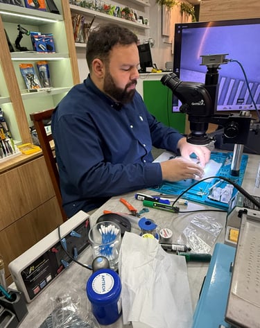 Professional technician performing micro-soldering on a circuit board using a digital microscope.