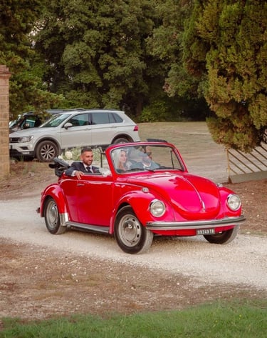 Maggiolone d'epoca con gli sposi a bordo che parte dalla chiesa per dirigersi verso la villa.