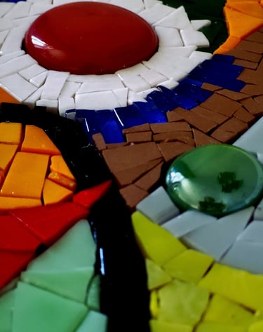 a colorful mosaic tile table with a red and white flower