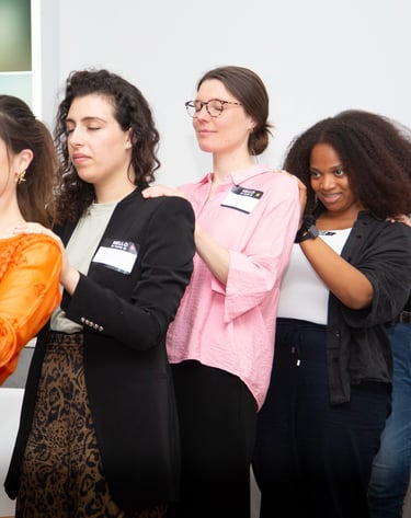 Women showing their support with hands on the backs of other women, female empowerment workshops. 