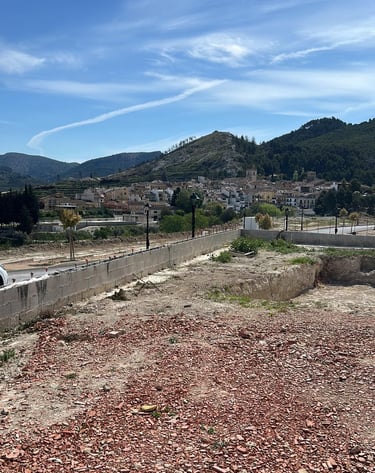 Vue panoramique d’un village espagnol niché dans des collines verdoyantes sous un ciel bleu