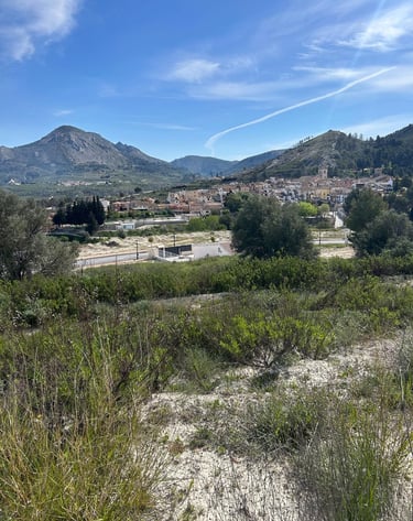 Vue panoramique d’un village de montagne espagnol traditionnel sous un ciel bleu, entouré de colline
