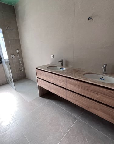 Salle de bains moderne avec double vasque en bois, murs en carrelage effet pierre, douche à l’italie