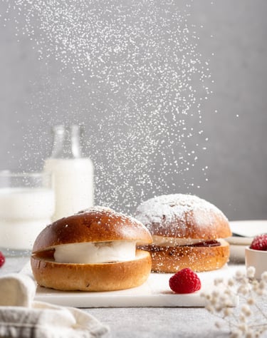 a couple of bundts with raspberries and cream and flying sugar powder