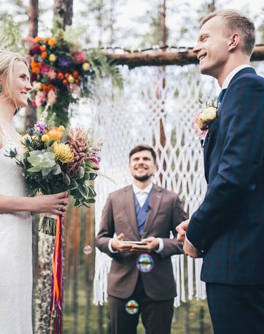 a bride and groom are getting married in a forest