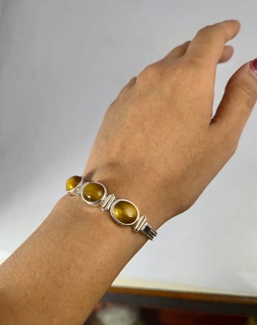 a woman's handmade bracelet with a tiger eye