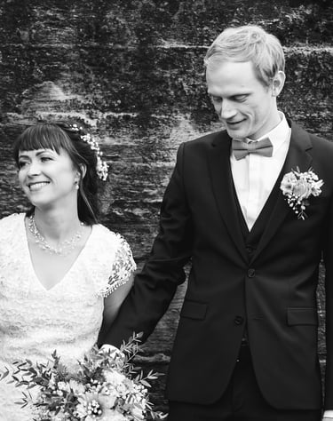a bride and groom holding hands and smiling