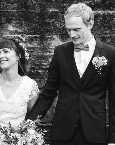 a bride and groom holding hands and smiling