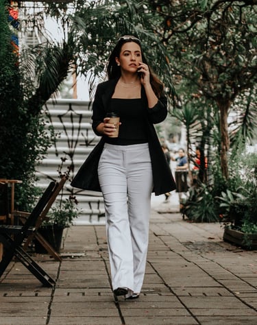 uma mulher caminhando pela calçada com uma xícara de café