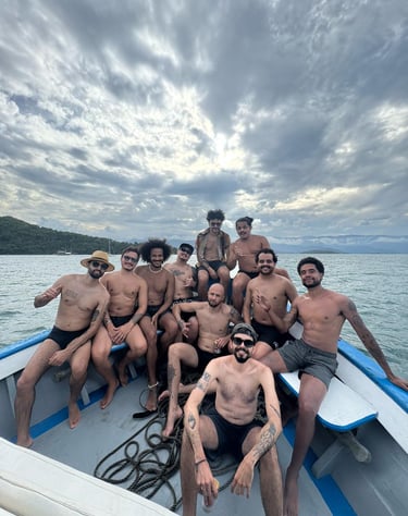 foto com clientes em uma despedida de solteiro, com o barco navegando em paraty