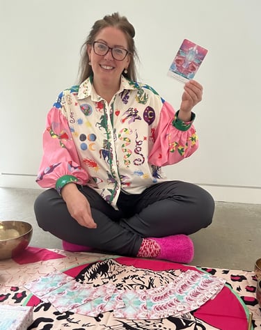 photo of gabi smiling at the camera holding an oracle card