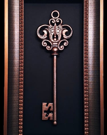 oversized decorative bronze key in a bronze frame
