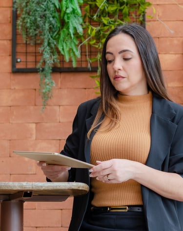 uma mulher de jaqueta preta e um tablet