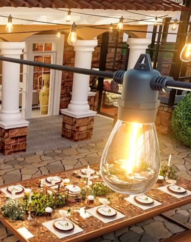 Warm outdoor string lights hanging over an elegant patio dining table set for a garden dinner party.