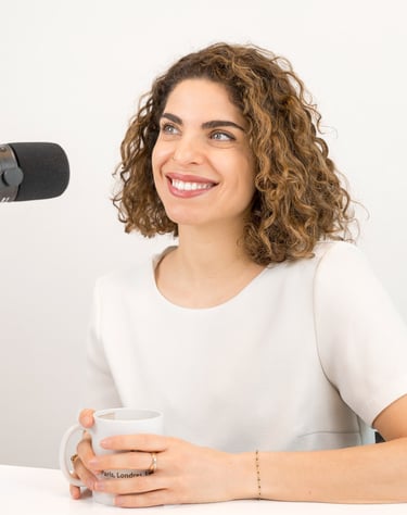Portrait professionnel d’une femme souriante en studio, devant un micro, dans un cadre épuré et lumineux usage podcast
