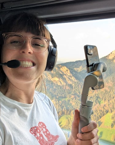 Laura sits in a helicopter over the Italian Dolomites with a gimble taking social media videos