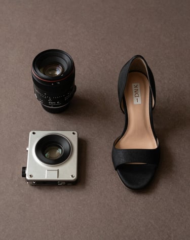 An artistic editorial photography shot of high-fashion accessories on a muted brown textured surface, minimalist and refined, North American / European aesthetic.