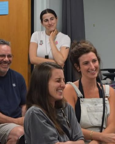 Diverse group of smiling colleagues enjoying a collaborative team meeting in a casual office setting.