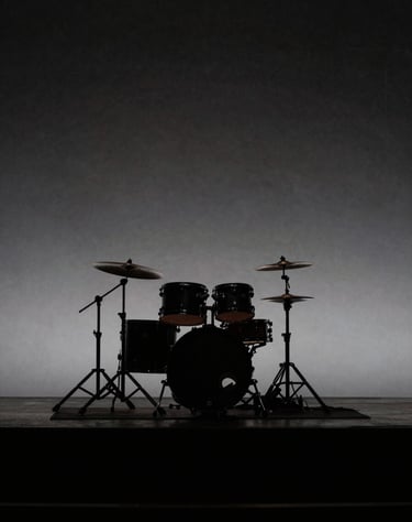 Silhouetted drum kit on an empty stage before a show. Minimalist, elegant, dark aesthetic using deep blacks and subtle gray highlights. Western European / Dutch concert hall.