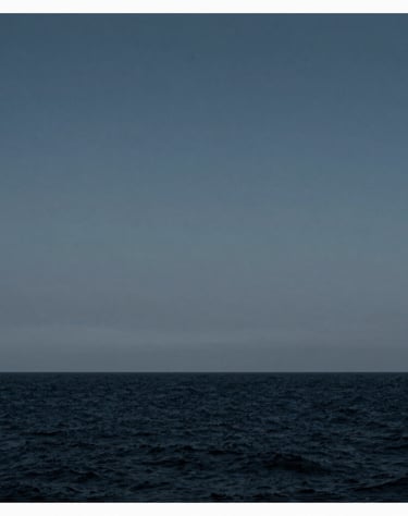 A minimalist composition of a distant horizon line between a dark navy sea and a steel blue grey sky, clean and serene, International / Western.