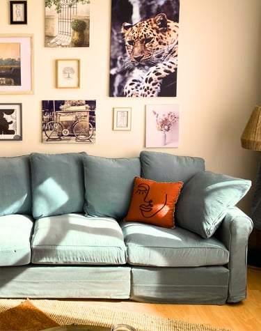 Coin salon cosy avec canapé bleu et déco murale dans hébergement professionnel.