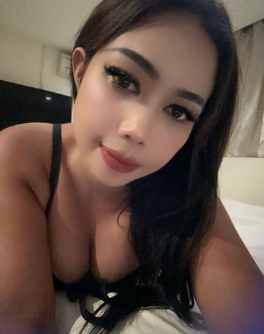 Lady lying on bed taking a close up selfie