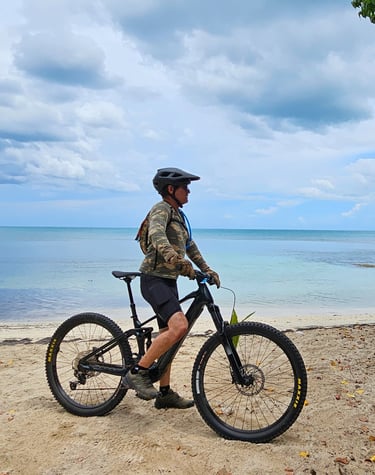 a man riding a bike on a beach