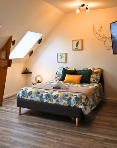 Chambre confortable sous combles avec lit double, idéale pour séjour d’un voyageur seul.