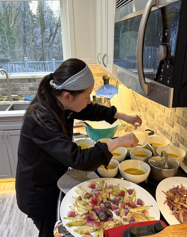 Personal chef Mia plating private fundraiser dinner on-site, soup roasted veg gluten-free dairy-free