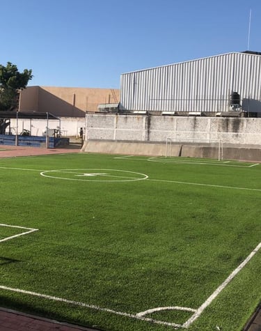 cancha de pasto sintetico de futbol dentro de una universidad