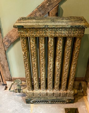 Vintage radiator with layers of paint applications and a faux painted pipe to match.