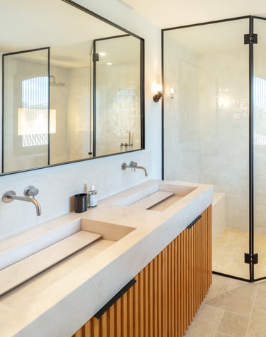 Modern bathroom with double vanity, walk-in rain shower, and natural light at Villa La Gratitud.