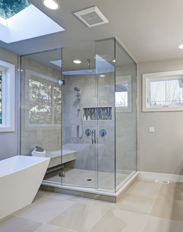Cozy bathroom with warm lighting, a freestanding tub, and elegant tile work.