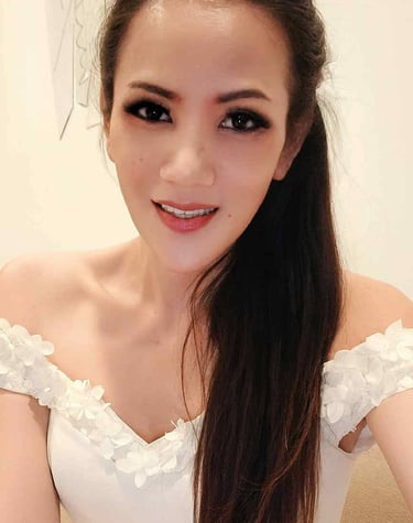 Ladyboy wearing a frilly of the shoulder white dress