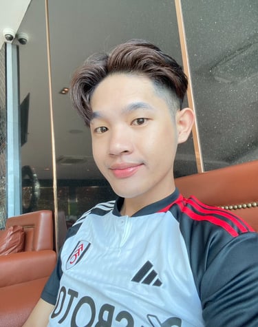 Thai male masseur sitting on a chair wearing a blue sports t-shirt.