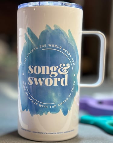 White coffee tumbler with blue splash "Song & Sword" "The Church the World Needs Now" "Song of Grace with the Sword of Truth"
