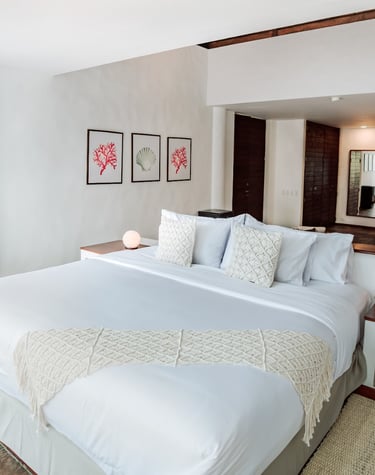 Oceanfront bedroom at Villa Escalesia in Puerto Ayora, featuring direct access to a private wooden t