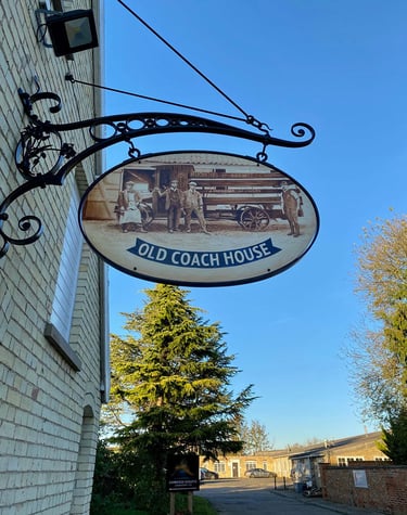 Cast iron pub sign with painting depicting former brewery staff