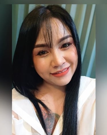 A massage therapist from Pattaya Home Massage wearing cream blouse revealing a tattoo