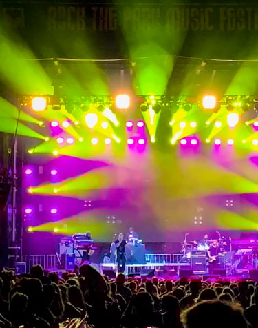 Lots of LED moving head fixtures on an outdoor stage at a music festival.