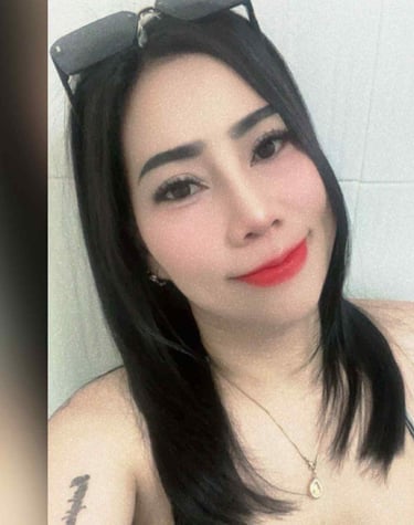 Half body shot of a lady wearing a black and white low cut top and sun glasses on her head.