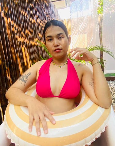 A lady wearing a red bikini sat in a bath tub