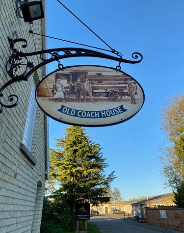 Cast iron pub sign with painting depicting former brewery staff
