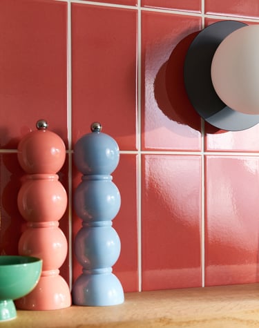 Glossy coral wall tiles with white grout in a modern kitchen splashback, featuring pastel pink 