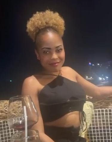 Lady sat outside in the evening with a glass of wine on table