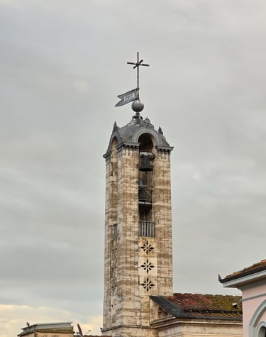 a clock tower with a weather vane and weather vanes