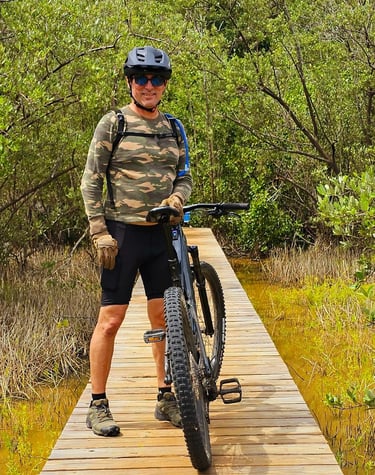 a man riding a bike on a wooden bridge