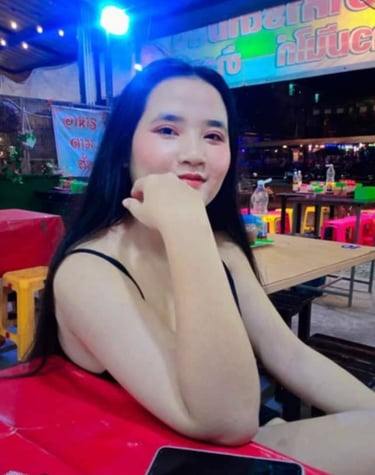 lady sat on chair with arm leaning on table and hand on chin