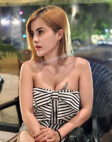 lady sitting on chair cross legged wearing a short black and white dress