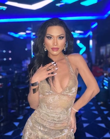 Ladyboy standing in a bar wearing beige short dress
